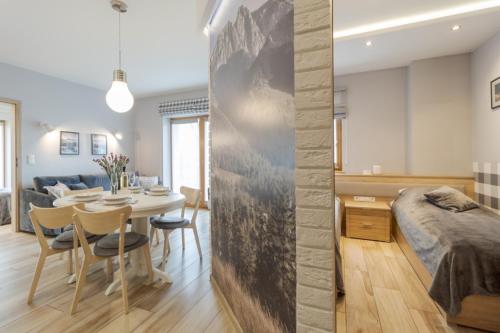 a bedroom and living room with a bed and a table at Pod Tatrami in Zakopane