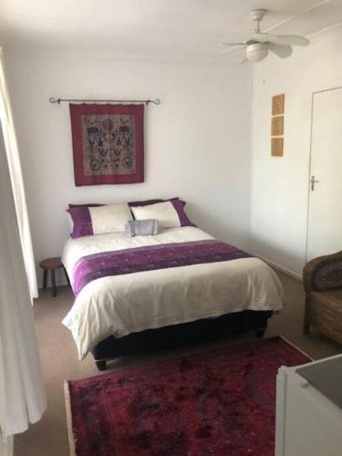 a bedroom with a bed and a ceiling fan at Welcoming One Bedroom Flatlet with Pool in Pietermaritzburg