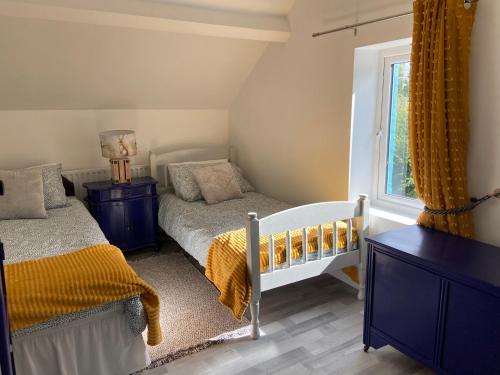 a bedroom with two beds and a window at Katie’s Cottage in Limerick