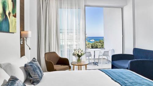a hotel room with a bed and a view of the ocean at Gaia Sun N Blue Hotel in Ayia Napa