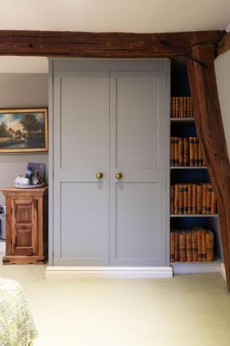 a room with white cabinets and a book shelf at The Crown, Bildeston in Bildeston