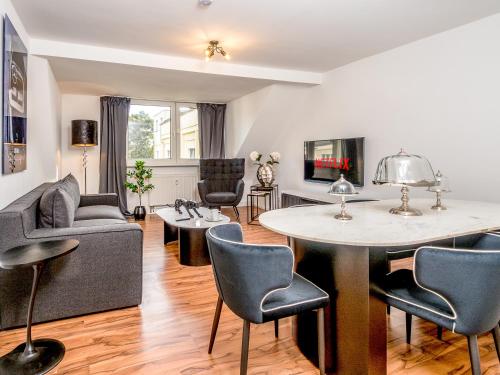 ein Wohnzimmer mit einem Tisch und Stühlen in der Unterkunft Exklusive und gemütliche Unterkünfte in Krefeld - JUNIK Apartments in Krefeld