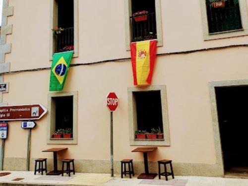 una señal de stop frente a un edificio con banderas en Tras do convento, en Samos