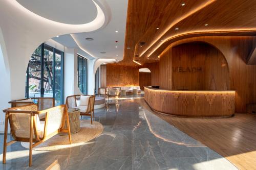 a lobby with a waiting area with wooden walls and chairs at VELA DHI Nakhon Phanom in Nakhon Phanom