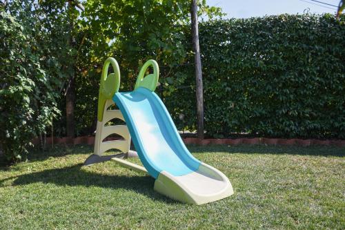 a blue and white slide in the grass at Apartmaji Sobe Zvezda in Pobegi