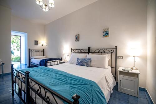 a bedroom with a large bed with a blue blanket at Sonnino B&B in Procida