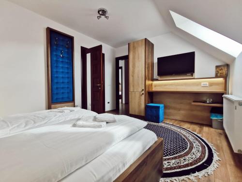 um quarto com uma cama grande e uma televisão de ecrã plano em Vila Platon em Valea Seacă