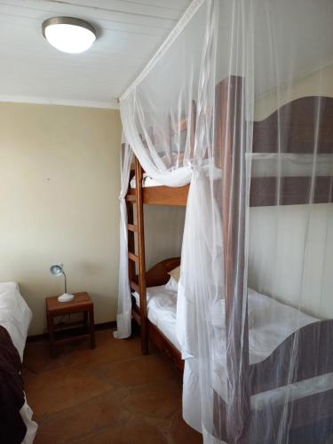 a bedroom with two bunk beds with mosquito nets at Okutala Etosha Lodge in Outjo