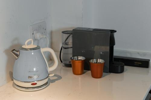 a kitchen counter with a tea kettle and a microwave at Luxury 2BDR in the Heart of Valletta! TV and WiFi in Valletta