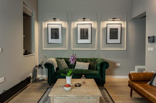 a living room with a green couch and a table at Luxury 2BDR in the Heart of Valletta! TV and WiFi in Valletta