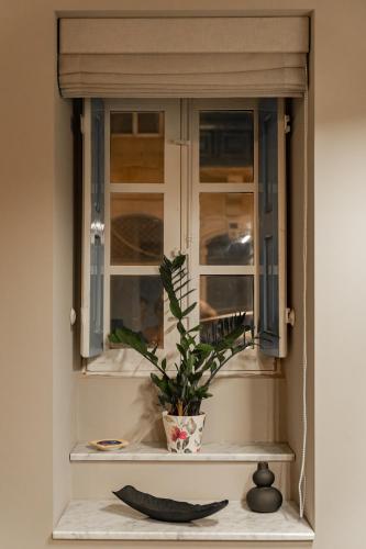 a window with a plant sitting on a window sill at Luxury 2BDR in the Heart of Valletta! TV and WiFi in Valletta
