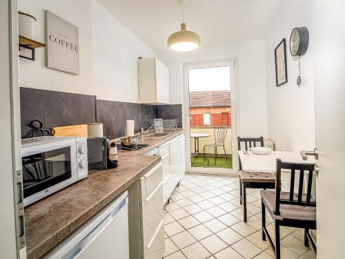 a kitchen with a counter top with a microwave at JUNIK Apartments "Am Sternbuschweg" in Duisburg