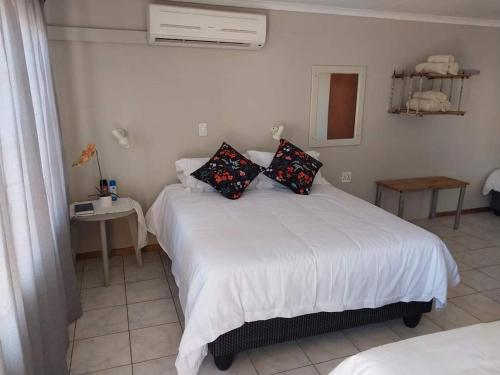 Un dormitorio con una cama blanca con almohadas. en Grunau Country Hotel en Grünau