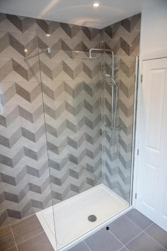 a shower stall with a glass door in a bathroom at Escape Ordinary in Enniskillen in Enniskillen