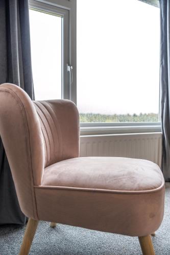 a brown chair in front of a window at Escape Ordinary in Enniskillen in Enniskillen