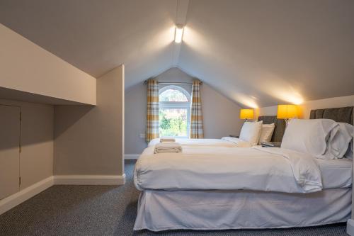 a bedroom with a large white bed with a window at Escape Ordinary in Enniskillen in Enniskillen