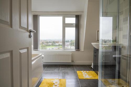 y baño con ventana, lavabo y ducha. en Escape Ordinary in Enniskillen, en Enniskillen
