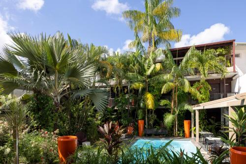 ein Resort mit Swimmingpool und Palmen in der Unterkunft Hotel Ker Alberte in Cayenne