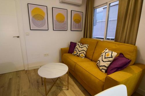 a living room with a couch and a table at Letmalaga Square Merced in Málaga