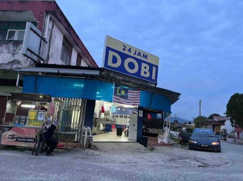 a dobi store with a sign on top of it at Homestay Malim Nawar in Malim Nawar
