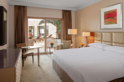 a bedroom with a large bed and a living room at Grand Hyatt Amman in Amman