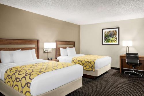 a hotel room with two beds and a desk at Baymont by Wyndham Whitefish in Whitefish