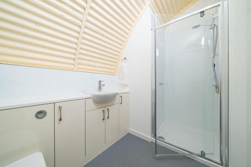 a bathroom with a sink and a shower at Cultybraggan Hut 34 in Mill of Fortune