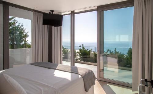 a bedroom with a bed and a view of the ocean at Luxury Glass Villas in Syvota