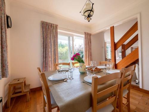 a dining room with a table and chairs and a window at The Nook in Stoke Fleming