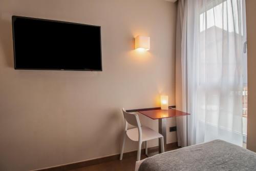 a room with a table and a television on the wall at SM Hotel Teatre Auditori in Barcelona