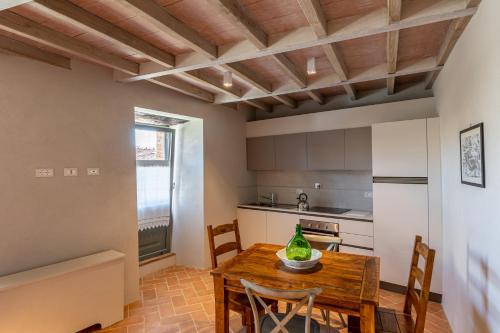 een keuken met een houten tafel en stoelen in een kamer bij Casa Mustiola in Montalcino