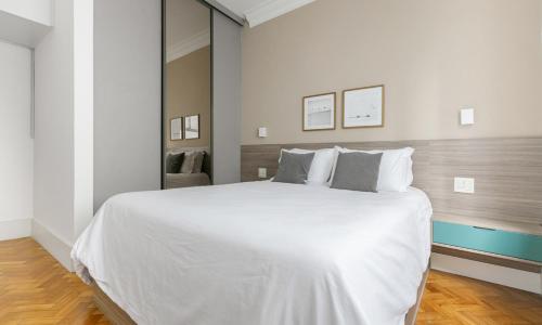 um quarto branco com uma grande cama branca com almofadas em Tabas Aconchegante ap 3qtos no Leblon LB0025 no Rio de Janeiro
