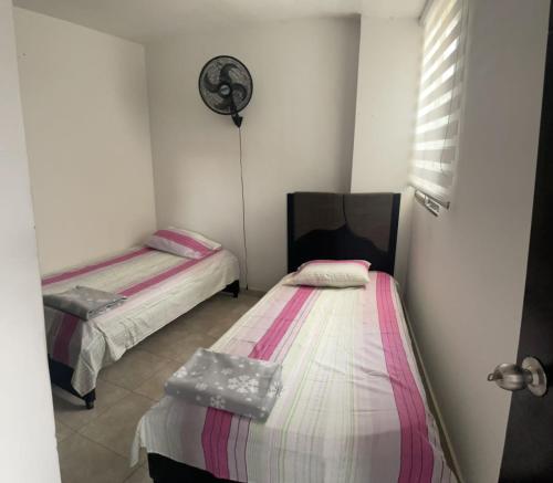 Habitación pequeña con 2 camas y ventilador. en Apartamento amoblado, en Sincelejo