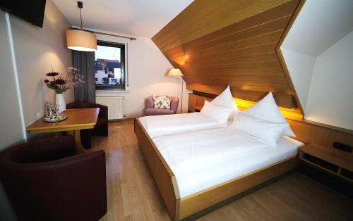 Habitación de hotel con cama, escritorio y ventana en Gasthof Hirsch, en Schollbrunn