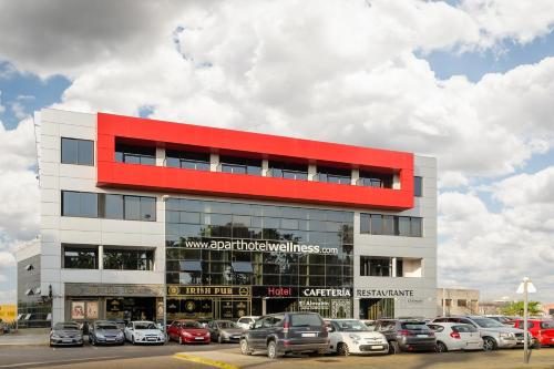 a building with cars parked in a parking lot at Aparthotel Wellness in Paterna