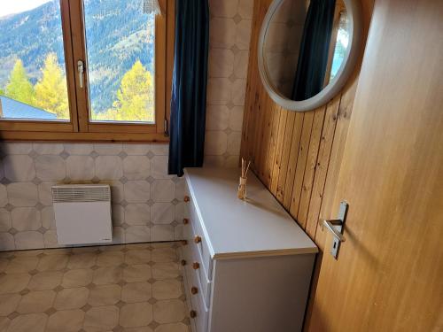 a bathroom with a sink and a mirror and a window at Ferienwohnung Traumzeit OG/DG in Bellwald