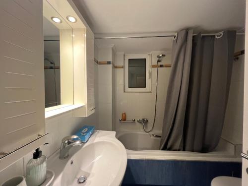 a bathroom with a sink and a tub and a shower at Hector Apartment Airport by Airstay in Spata