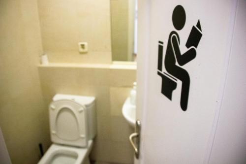 a bathroom with a white toilet and a sink at Onefam Sungate in Madrid