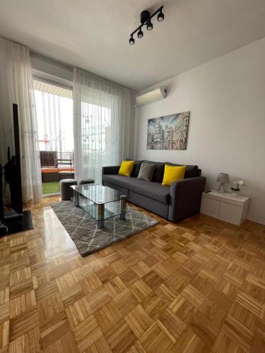 salon z kanapą i szklanym stołem w obiekcie Calle Orense, Madrid w Madrycie
