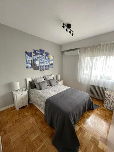 sypialnia z łóżkiem i drewnianą podłogą w obiekcie Calle Orense, Madrid w Madrycie