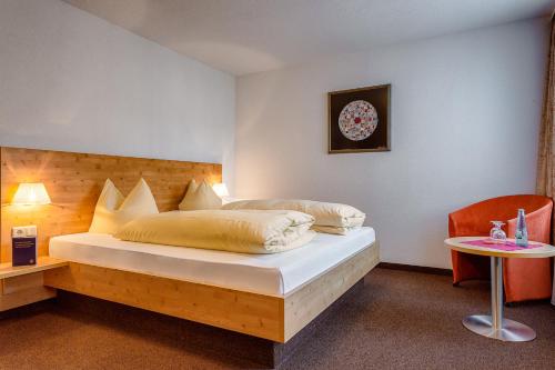1 dormitorio con cama, mesa y reloj en Gasthaus zum Kranz en Lörrach