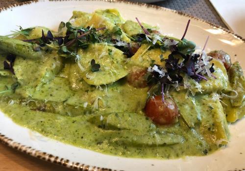 a plate of food with green sauce and vegetables at Gasthof Hirsch in Schollbrunn