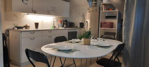 - une table dans une cuisine avec une table et des chaises blanches dans l'établissement Wooden box with sleeping amenities Vindegade 53E, à Odense