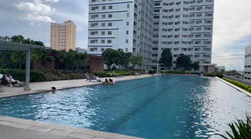 a swimming pool in the middle of a city with buildings at 8 Sun Staycation in Manila