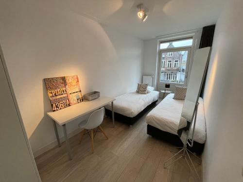 Habitación pequeña con 2 camas y escritorio. en Residences Rijksmuseum, en Ámsterdam