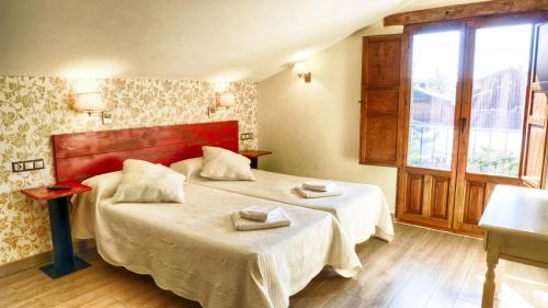 a hotel room with two beds and a window at Casa rural El Roble Hueco in Campillejo