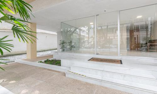 un bâtiment doté d'une grande fenêtre en verre avec des plantes dans l'établissement Tabas Espaçoso apê no Jardim Botânico JB0003, à Rio de Janeiro
