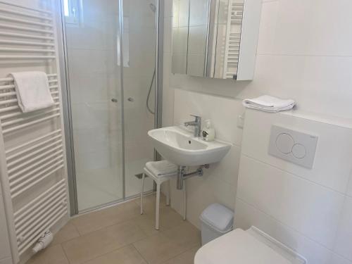 a white bathroom with a sink and a shower at Hotel Michael in Gerasdorf bei Wien
