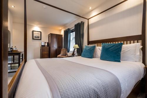 a bedroom with a large bed with blue pillows at The Howbeck & The Retreat incl FREE off-site Health Club and FREE parking in Windermere