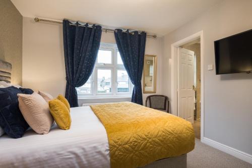 a bedroom with a bed with blue curtains and a window at The Howbeck & The Retreat Central location, incl off-site Health Club and parking EV point available, GREAT DEALS ON in Windermere